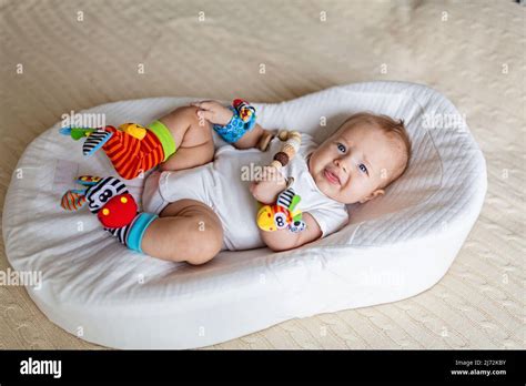 Cute Caucasian Blonde Baby Three Months Old Lying In Cocoon At Home Kid Wearing On Hands And