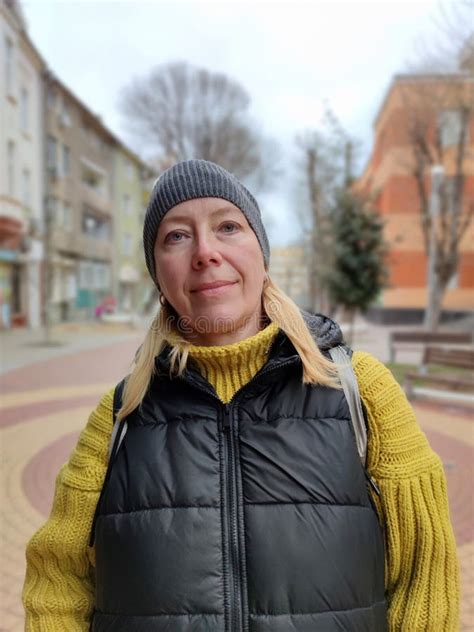 Portrait Of Smiling Blonde Middle Aged Woman Outdoors Stock Photo