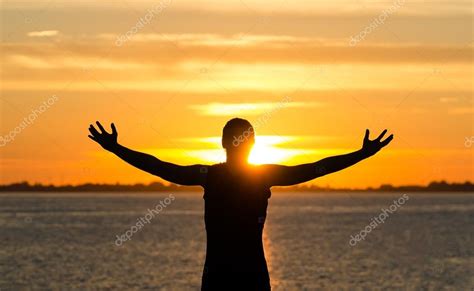 Man With Arms Wide Open On The Beach At Sunrise Stock Photo By