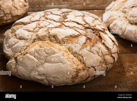 Large Loaves Of Bread Baked In A Wood Fired Oven On A Wooden Surface