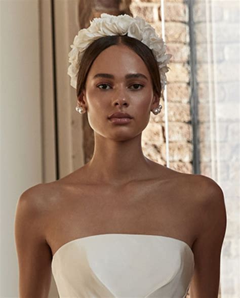 A Woman In A Strapless White Dress With Flowers On Her Head And Hands