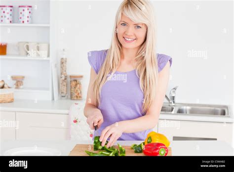 Beautiful Blonde Woman Cutting Vegetables In Modern Kitchen Interior