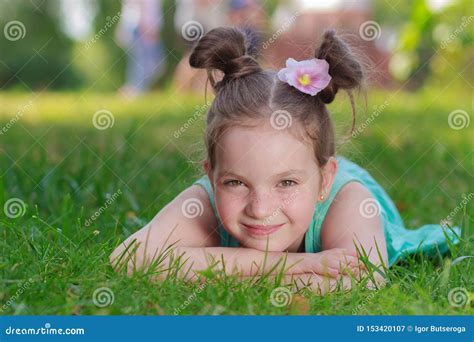 Cute Girl Lying On The Green Grass Outdoors Summer Time Blurred