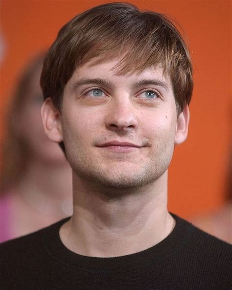 a close up of a person wearing a black shirt and looking into the ...