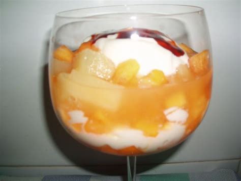 A Glass Filled With Fruit And Ice Cream