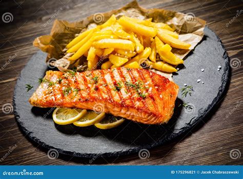 Grilled Salmon Steak With French Fries And Lemon Slices Stock Image