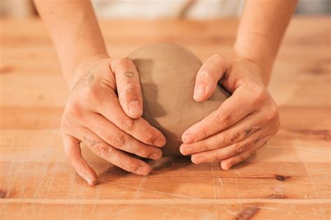 Mano De Mujer Amasando La Arcilla En Mesa De Madera Foto Gratis