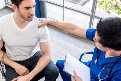 Athlete Male Patient Consulting With Doctor For Shoulder Pain Stock