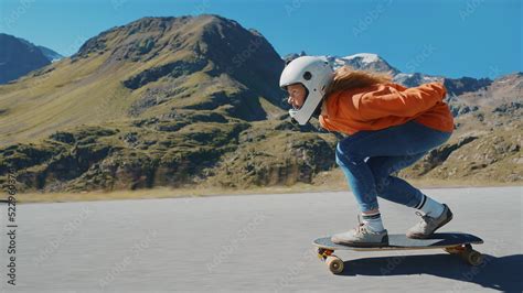 Cinematic downhill longboard session. Young woman skateboarding and ...