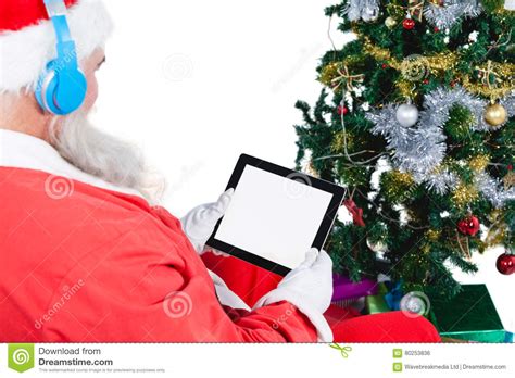 Santa Claus Using Digital Tablet With Christmas Tree And Gifts Stock