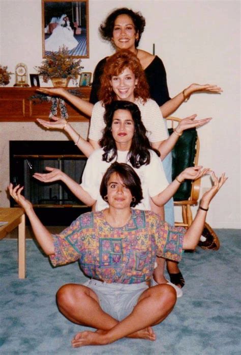 Four Women Are Sitting On The Floor With Their Hands In The Air