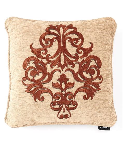 A Decorative Pillow With An Embroidered Design On The Front And Back Of It In Brown