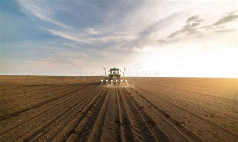 Farmer With Tractor Seeding Soy Crops At Agricultural Field Stock Photo