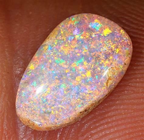 An Opalite Stone Sitting On Top Of Someone S Hand