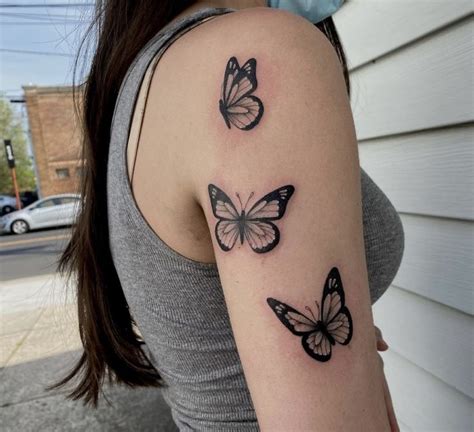 A Woman S Arm With Three Butterflies Tattooed On The Left Side Of Her Arm