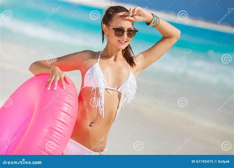 La Mujer Hermosa En Bikini Con Un Salvavidas Rosado Imagen De Archivo