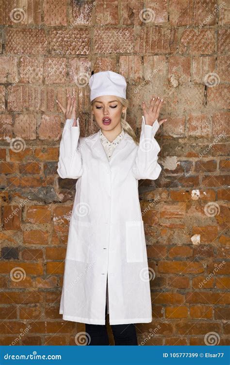 Het Portret Van Een Knappe Jonge Blonde Verpleegster Met Haar Wapens Kruiste Op Een Witte