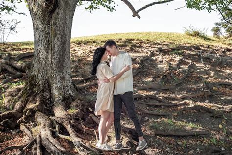 Um cara e uma garota um casal apaixonado fica debaixo de uma árvore e