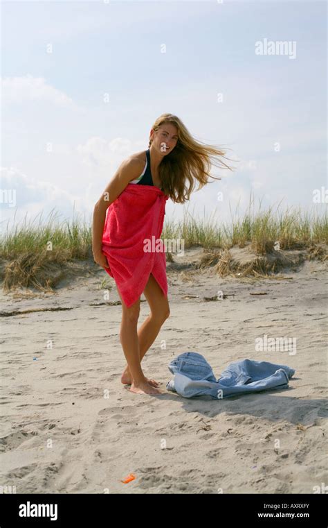 Jeune femme blonde est en train de changer les vêtements à la plage Photo Stock Alamy