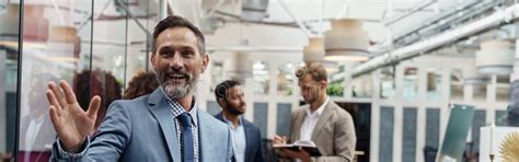 Mature Smiling Businessman Standing Office Colleagues Background Waving