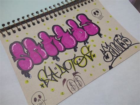 A Spiral Notebook With Graffiti Written On It