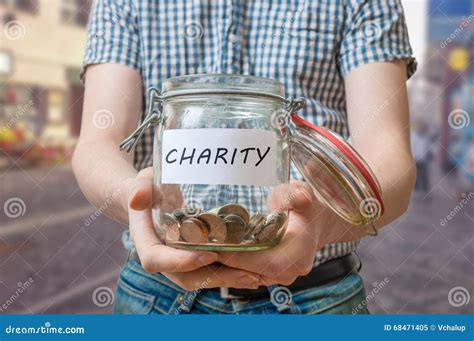 Man Standing On Street Is Collecting Money For Charity And Holds Jar