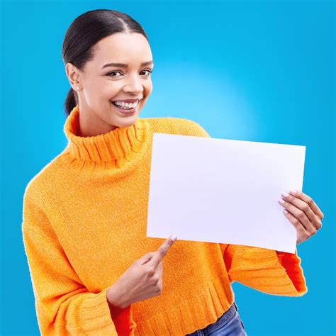 Señalando maqueta y afiche con retrato de mujer en estudio para marca