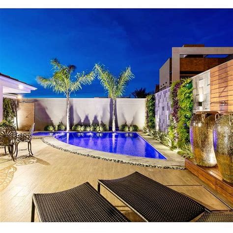 An Outdoor Swimming Pool With Lounge Chairs And Palm Trees Next To It