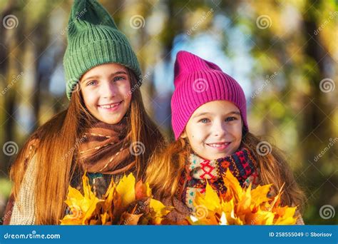 Two Cute Smiling 8 Years Old Girls Posing Together In A Park On A Sunny