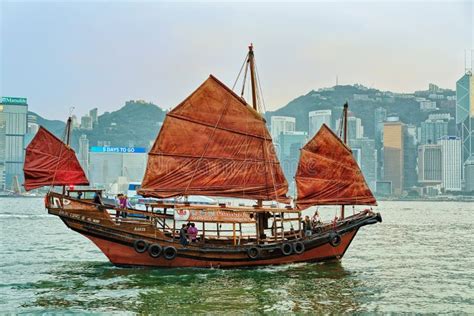 Junk Boat At Victoria Harbour In Hong Kong At Sunset View From Kowloon