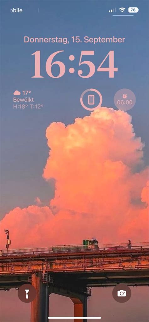 An Image Of The Sky And Clouds Above A Bridge That Is Lit Up In Pink