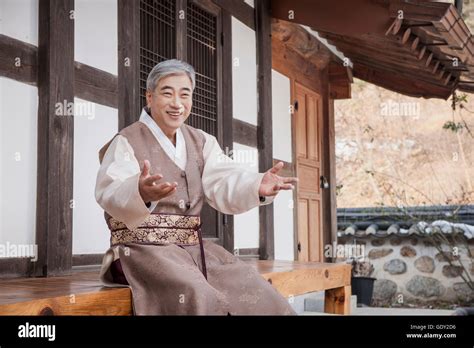 Smiling Old Man In Traditional Korean Clothes Sitting On Floor Of