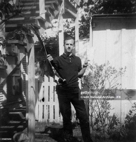 Lee Harvey Oswald holds a Mannlicher-Carcano rifle and a newspaper in... News Photo - Getty Images