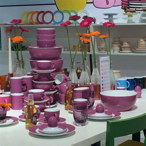 A Table Topped With Lots Of Purple Cups And Saucers Next To Plates And