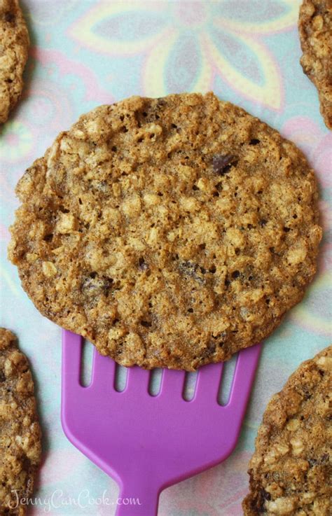 An Oatmeal Cookie And A Purple Plastic Fork On A Colorful Tablecloth