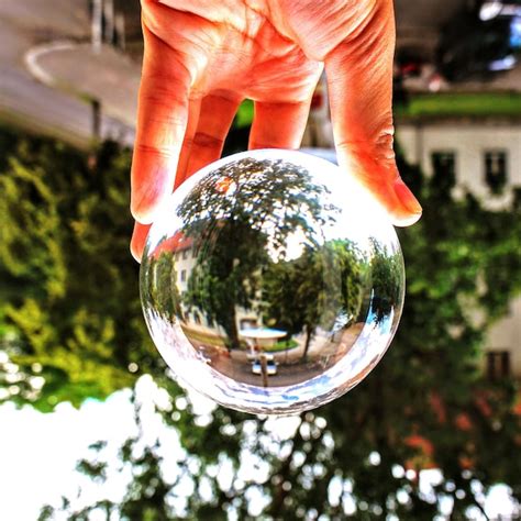 Premium Photo Cropped Hand Of Person Holding Crystal Ball With Reflection