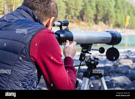 Tourist Looking Through Telescope View From Back Valley Of Mountain