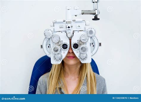 Pretty Young Woman Doing Eyesight Measurement With Optical Phoropter In Ophthalmology Clinic