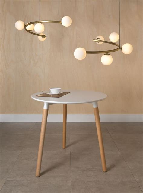 A White Table With Some Lights Hanging From It S Sides And A Bowl On Top