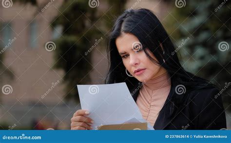 Cerrar A Una Joven Seria Sentada Afuera Leyendo Carta De Papel Triste