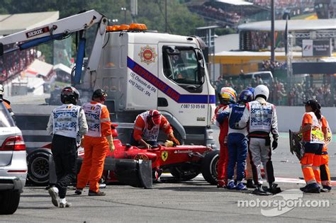 Fernando Alonso, Ferrari is helped from his car after a crash at the ...