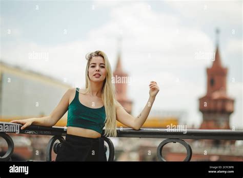 Belle mannequin blonde penchée sur une rampe le jour de l été À Berlin sur un arrière plan flou