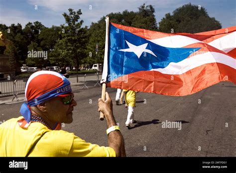 A reveler marches along 5th Ave. waving a Puerto Rican flag during the National Puerto Rican Day ...