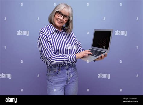 Smiling 60s Mature Woman With Gray Hair With Laptop Mockup On Bright