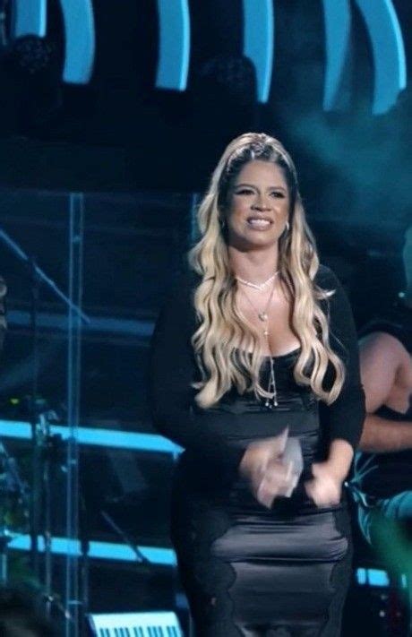 A Woman In Black Dress Standing On Stage