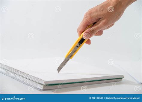 Hand with a Cutter in Hand Cutting the Sheet of a Notebook Stock Image ...