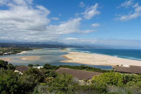 An Aerial View Of The Beach And Ocean With Houses In The Foreground