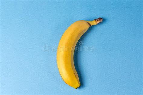 Estilo Do Minimalismo Banana Amarela Madura Sobre O Fundo Azul Imagem