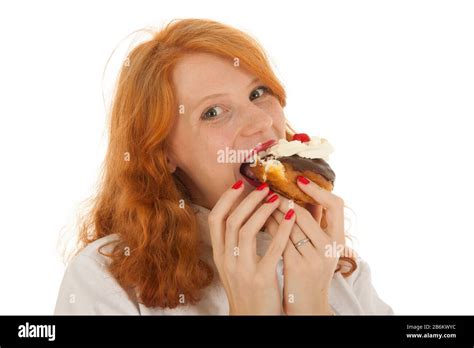 Female Baker Chef With Red Hair Eating Pastry Isolated Over White