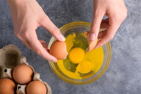 Premium Photo Housewife Hands Cracking Fresh Egg Yolk And White